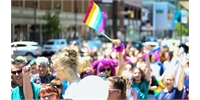 a crowd at a pride event with a lgbt flag