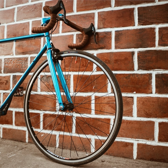 a blue road bike against a brick wall
